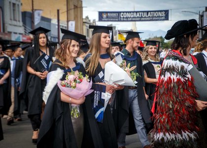 Graduates in procession wearing academic dress