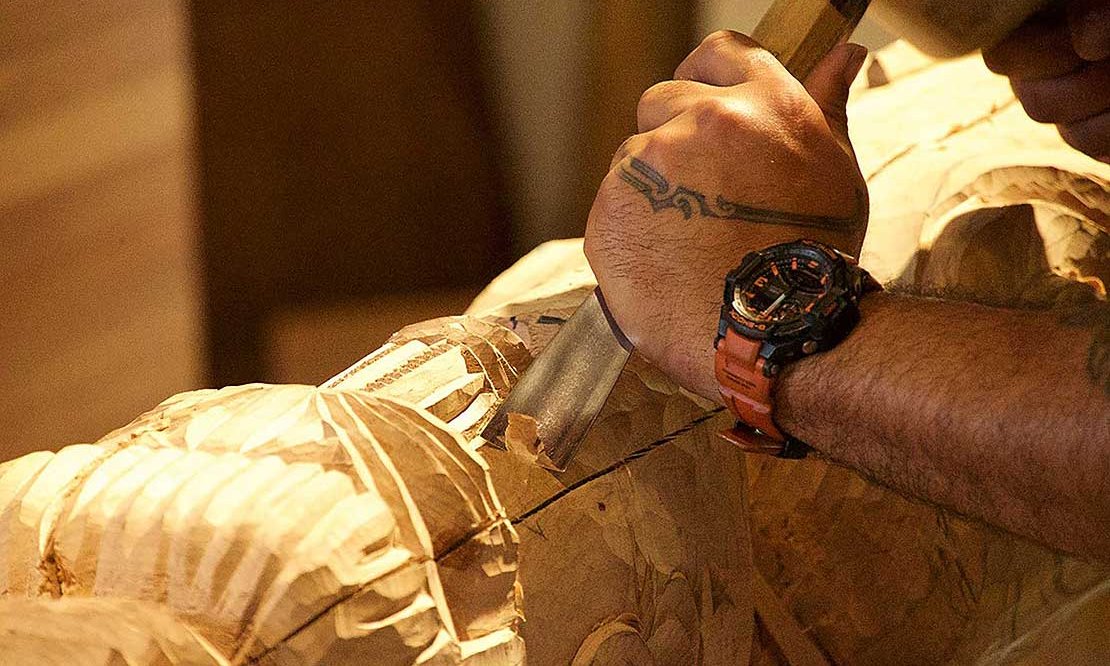Detail of a man carving with traditional tools by hand