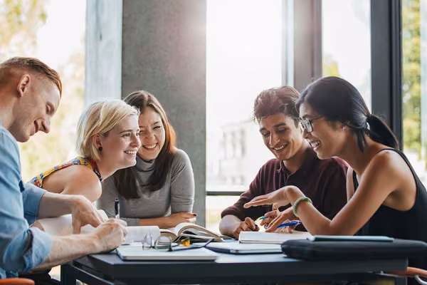 Smiling group with books taking notes