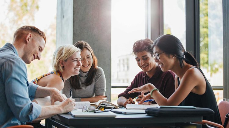 Smiling group with books taking notes