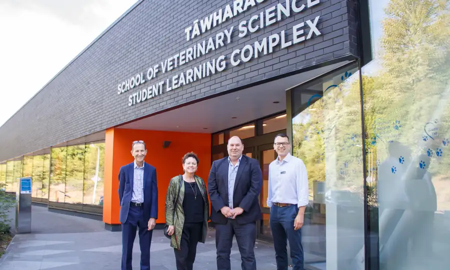 Four people standing outside in front of a building