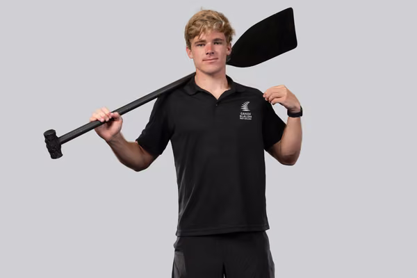 man standing looking at camera holding paddle