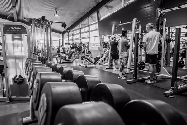 Black and white photo of students sharing the gym facilities