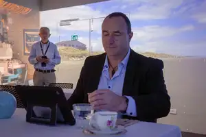 man at table drinking milk