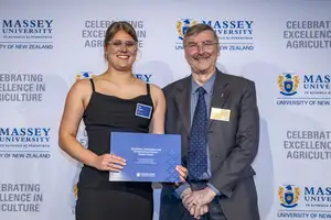 Award winner Kate Simpson holding her certificate alongside Dr John Caradus from NZIAHS at the Massey Agriculture Awards.