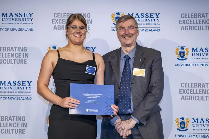 Award winner Kate Simpson holding her certificate alongside Dr John Caradus from NZIAHS at the Massey Agriculture Awards.