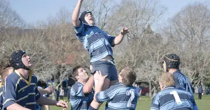 Rugby player being lifted to reach the ball, by fellow team players