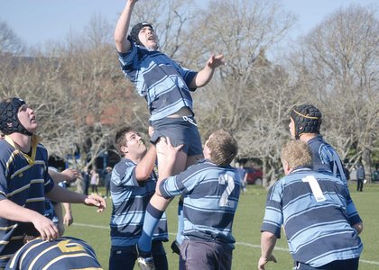 Rugby player being lifted to reach the ball, by fellow team players