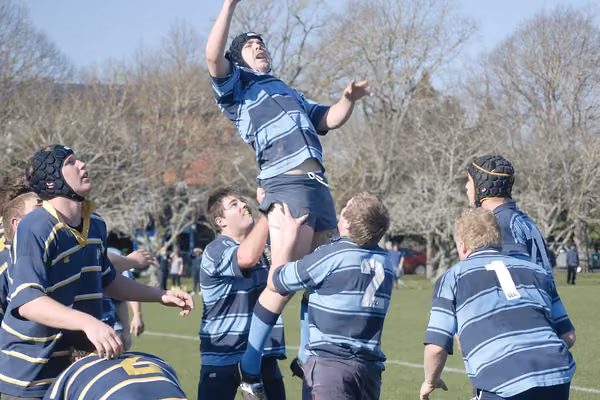Rugby player being lifted to reach the ball, by fellow team players