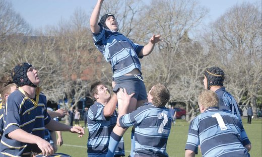 Rugby player being lifted to reach the ball, by fellow team players