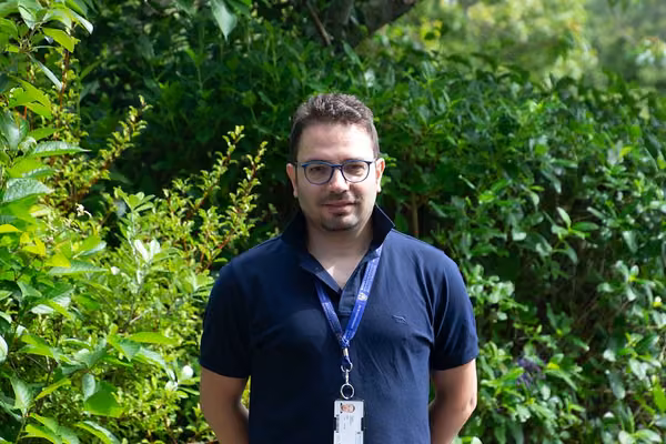 man standing in front of leafy background