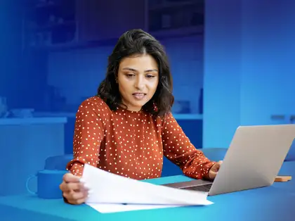 Student studying at desk with laptop.