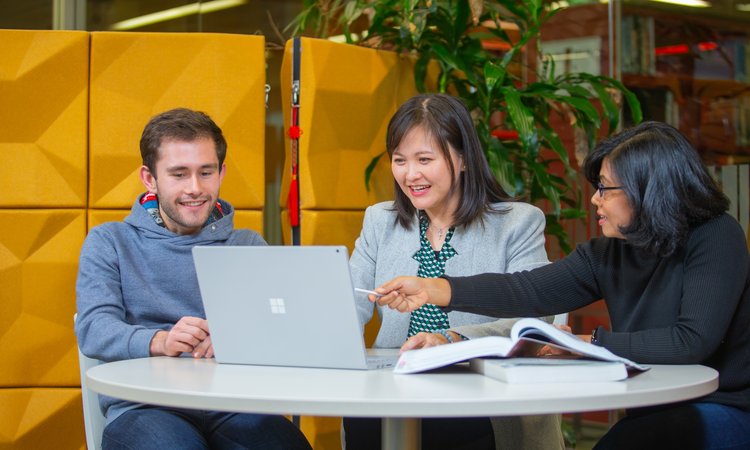 MBA students and lecturers working at a computer