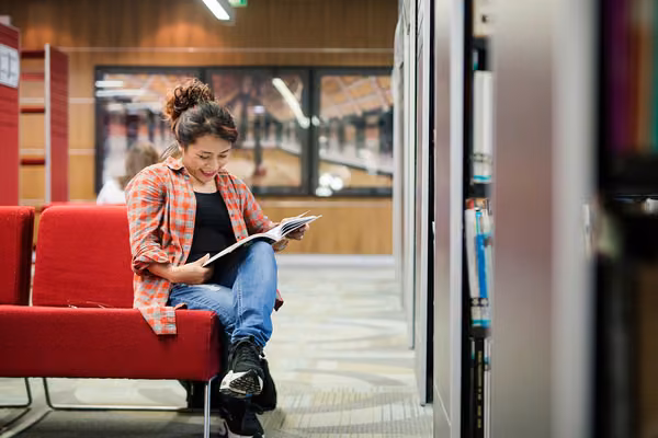 Women sitting in library reading book