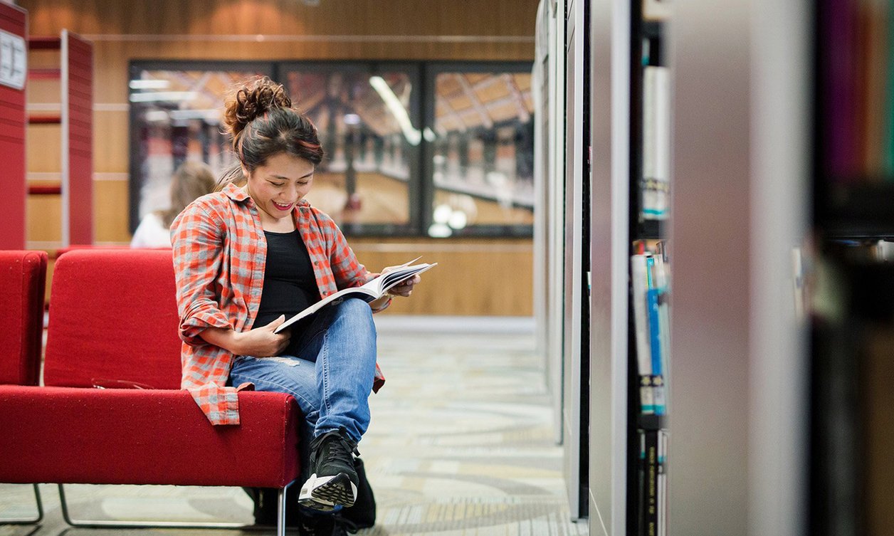 Women sitting in library reading book