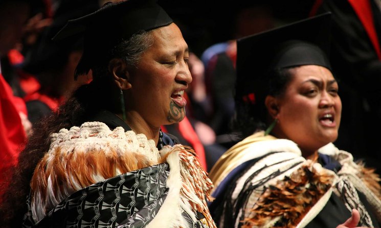 Close-up of two people performing a Karakia – Incantation, in traditional Maori cloaks