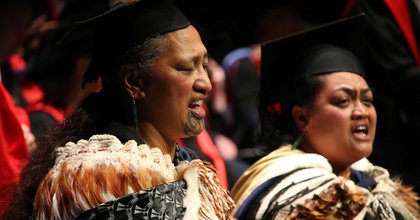 Close-up of two people performing a Karakia – Incantation, in traditional Maori cloaks