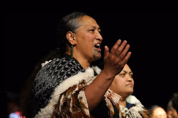 Close up of a person performing a waiata with a group