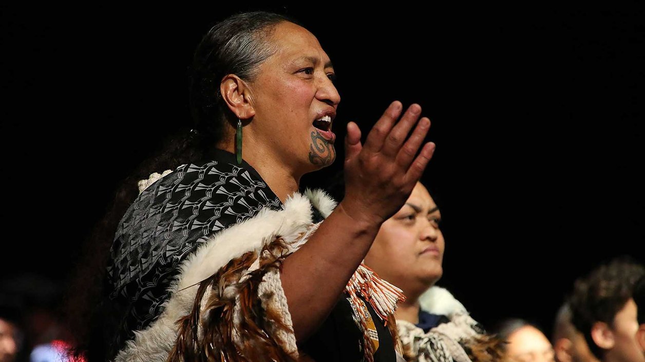 Close up of a person performing a waiata with a group