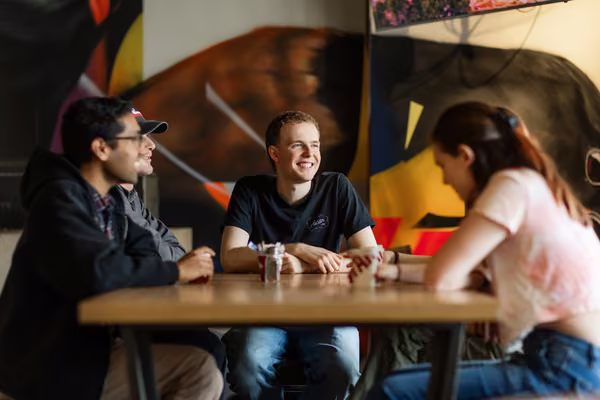 Group of people having a conversation at Tussock cafe.
