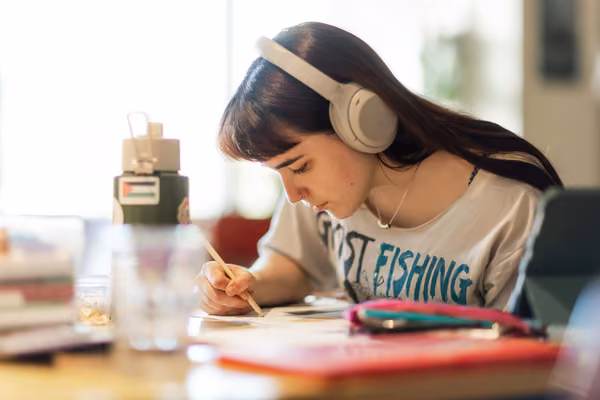 Student leaning on desk drawing on notepad