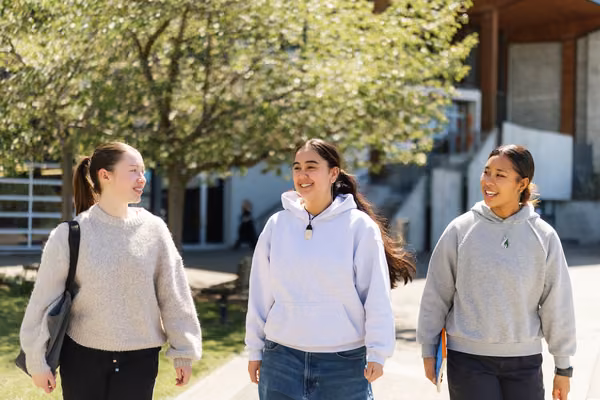 3 students walking outside Tussock cafe on Wellington campus.