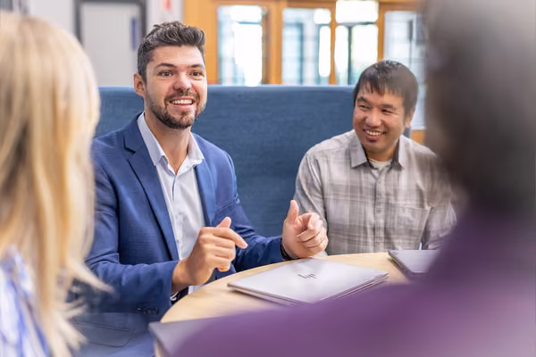 A person smiling at a business table.