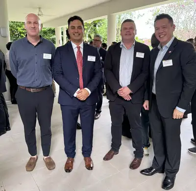 Four men in suits standing together smiling