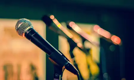 Series of microphones set up for a media confererence.