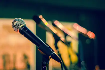 Series of microphones set up for a media confererence.