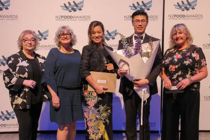 Fiona Smith, Franky Yang, Jenny Zo, Ginny Grant and Kelli Brett standing in front of the Food Awards banner.