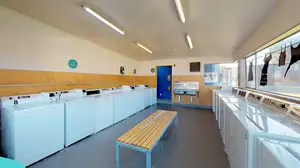 Matai, Miro, Tawa and Totara Halls's laundry with fourteen washing machines and a bench seat