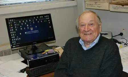 elderly man sitting at a computer desk