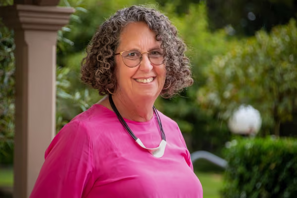 A woman wearing a pink top