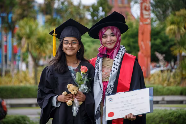 Graduates dressed in academic regalia and cultural dress.
