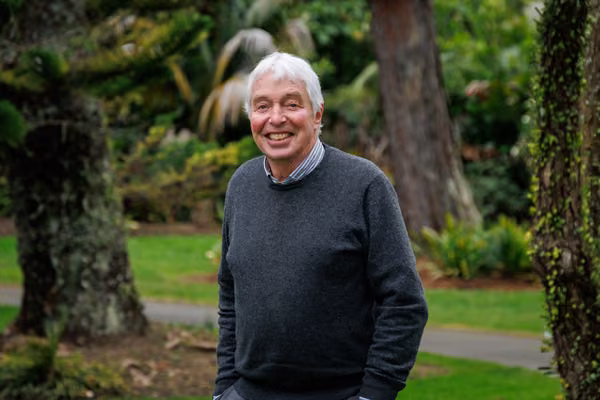 Professor Emeritus Ralph Sims standing in front of greenery on Massey's Manawatū campus.