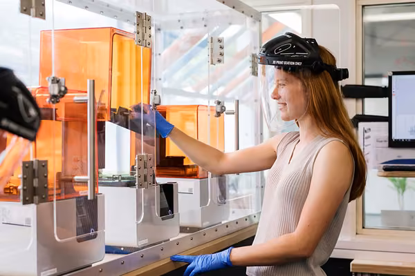 Smiling person with a 3D printer