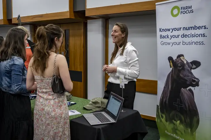 Students talking with a Farm Focus representative at the Massey Agriculture Awards sponsors expo.
