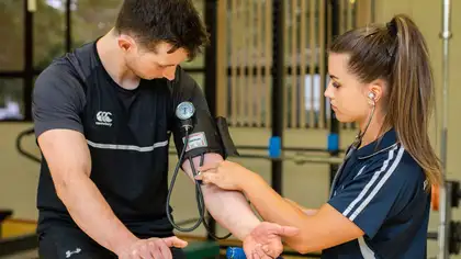 Student testing blood pressure of another student