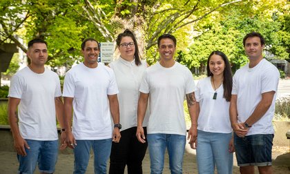 Group of six people of the Te-Rau-Tauawhi team standing outside, all wearing white t-shirts and denim pants