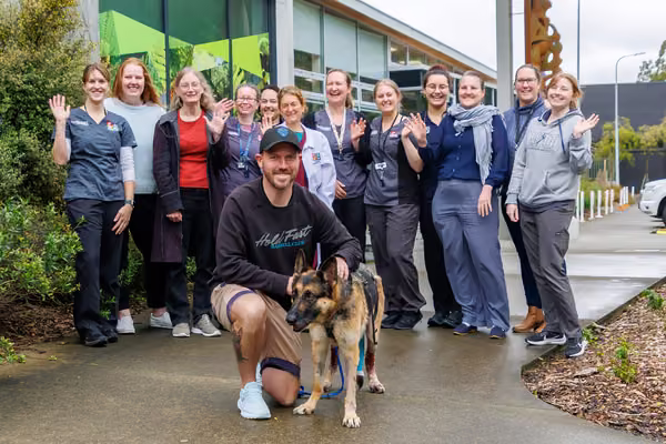 group of people outside vet clinic with German Shepherd