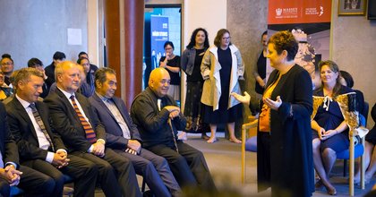 Massey University VC, Professor Jan Thomas speaking to a seated group about what happens at a pōwhiri