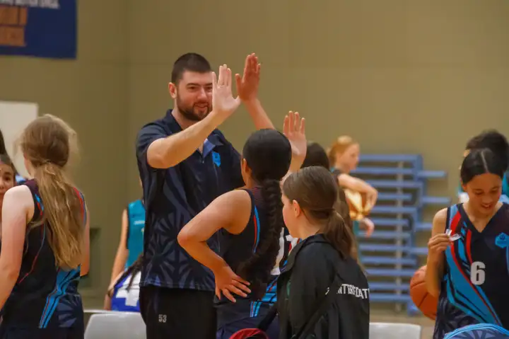 young athlete hi-fiving her coach