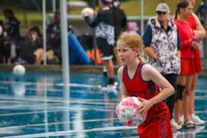 girl on court holding netball