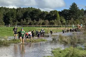 crowd of people running outside through mud