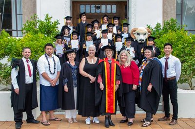 Image of children and academic staff in graduation gowns