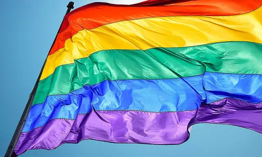 Close-up of rainbow flag showing stripes of red, yellow, green, blue and purple
