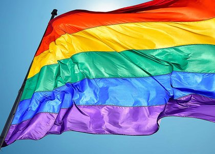 Close-up of rainbow flag showing stripes of red, yellow, green, blue and purple