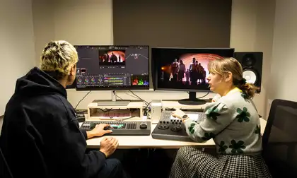 Two people editing movies on a computer