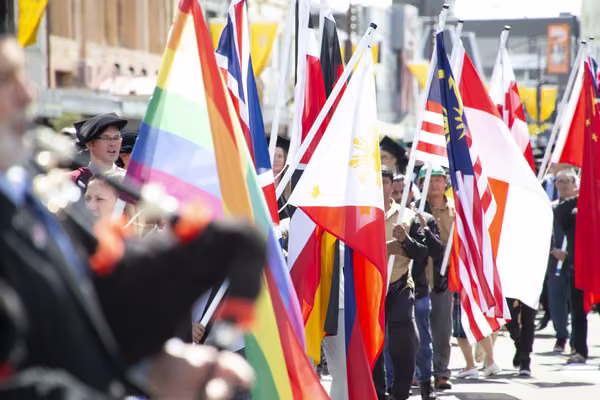 People carrying different flags at a graduation ceremony